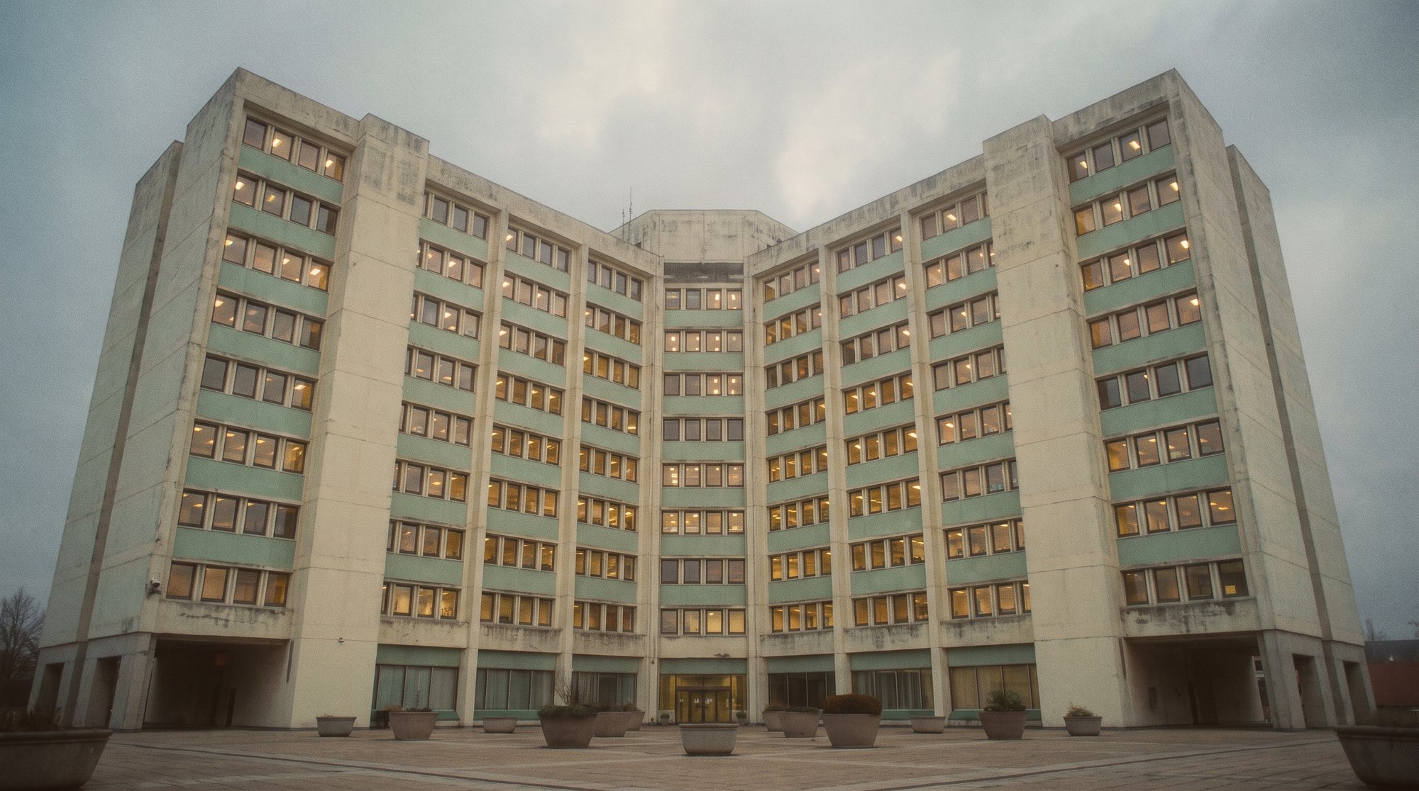 An enormous institutional building photographed from below at dusk.
